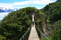 Backpacker over a suspension bridge in Torres del Paine, Chile