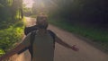 Backpacker raising hands and deep breathing fresh air. Tourist with backpack standing in sunset