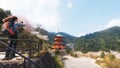 Backpacker taking photo of Nachi Taisha in Kumano Kodo pilgrimage routes, the tallest water fall in Japan with three Royalty Free Stock Photo