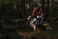 Backpacker Tourist With Aussie Australian Breed Dog Taling a Rest Afther Strolling In Forest. Active Lifestyle With Pets