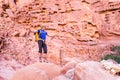 Backpacker tourist man standing desert stone canyon mountain trail Royalty Free Stock Photo