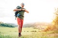 Backpacker traveler fastening sternum strap on backpack and preparing for trekking at summertime sunny day