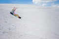 Backpacker in unicorn costume sliding down the snowy hill Royalty Free Stock Photo