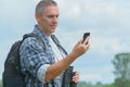Backpacker using smart phone Royalty Free Stock Photo