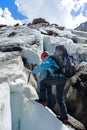 Backpacker woman with ice-axe climbing on glacier Royalty Free Stock Photo