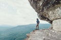 Traveler girl standing on cliff.