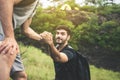 Backpackers man getting help to friend climb at nature,Helping hand,Overcoming obstacle concept