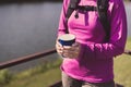 Backpacking Asian woman hand holding a glass of warm coffee in the morning at outdoor,Camping hiking concept Royalty Free Stock Photo