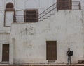 Backpacking traveller looking at the beauty of the Red Fort with white walls and brown doors in the background.