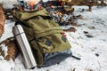 Backpack in the background of a burning bonfire in the winter forest. Winter trip.