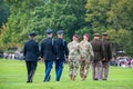 The backs of a line of Army military officers including generals on the parade field at the West Point Military Academy