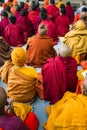 Backs of small group of buddhist praying monks. Lumbini, Nepal