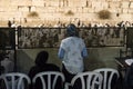 Backs of two Jewish women in women's section watching men praying at Western Wall, Judaism s holiest prayer site in the Old City