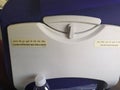 Backside of aeroplane seat with seatbelt message written in english and hindi language