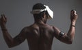 Backside of African male muscular athlet with naked torso using vr headset Royalty Free Stock Photo
