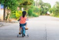 Backside of asian toddler girl child learning to ride bicycle in sunny summer day, kid cycling at park, baby sport concept Royalty Free Stock Photo