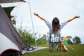 Backside of asian woman sitting on picnic chair and enjoying with beautiful nature while camping with family in the camping site.