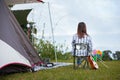 Backside of asian woman sitting on picnic chair and enjoying with beautiful nature while camping with family in the camping site.