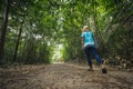 Backside of asian woman is walking in the forest and enjoy with nature