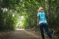 Backside of asian woman is walking in the forest and enjoy with nature