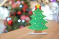 Backside Christmas tree paper craft decoration on the wood table with blur big Christmas tree behide