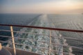 Backside of a cruise ship with ship railing in front and sea in the background during sunset Royalty Free Stock Photo