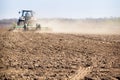 backside cultivator raises great dust on ploughed soil