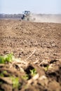 Backside cultivator raises great dust on ploughed soil
