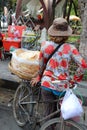 Backside of kite cracker seller, kite cracker in the clear plastic bags on the threshing basket for sale on her bicycle