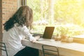 Backside of long hair asian woman business working with laptop in coffee shop.E-commerce, university education, internet Royalty Free Stock Photo