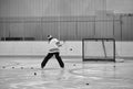 Backside of a man shooting pucks on a hockey net Royalty Free Stock Photo