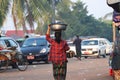 Backside of Myanmese woman put big aluminum enameled basin on her head to bring the products to the market