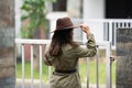 Backside portrait of an Indian young girl standing near a fence wearing garage mechanic attire and a cowboy hat. Indian lifestyle Royalty Free Stock Photo