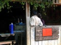 Backside of two local people standing in their tradition food shack, vintage shop, breaking time in small wooden shed, local Royalty Free Stock Photo