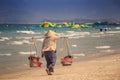 Backside View Vendor Woman with Yoke Walks on Beach