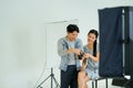 The photographer using digital camera taking picture of the female model in the creative home studio Royalty Free Stock Photo