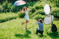 Backstage of a professional photo shoot in nature. Photosession of the model on the open air. Beautiful emotional girl posing in