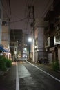 Backstreet at night lined with buildings and electric cables Royalty Free Stock Photo