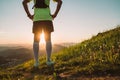 Backview of Active mountain trail runner dressed bright t-shirt with backpack enjoying the sunset while he sky running by