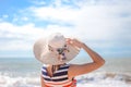 Backview of elegant lady in straw hat standing on Royalty Free Stock Photo