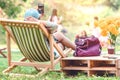 Backview of happiness woman on a summer holiday sitting on  garden chair to relax Royalty Free Stock Photo