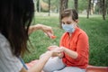 Backview of woman holding hand sanitizer and cleansing her child`s hands