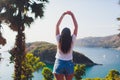 Backview woman traveler posing with raising arms relaxing on viewpoint at islands. perfect fit body woman. Portrait of