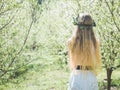 Backview of young beautiful woman in spring blossom trees.