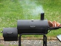 Backyard barbequing on a charcoal smoker Royalty Free Stock Photo