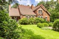 Backround yard of a beautiful english style house with bushes and green lawn. Real photo