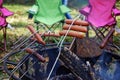 Backyard camping cooking hot dogs over a fire pit