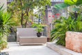 Small backyard area with cane chair and table surrounded by evergreen plants Royalty Free Stock Photo