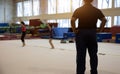 Backyard of coach in gymnastic kid practice in gym Royalty Free Stock Photo