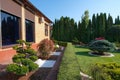 Backyard garden with nicely trimmed bonsai, bushes and bushes in side of villa Royalty Free Stock Photo